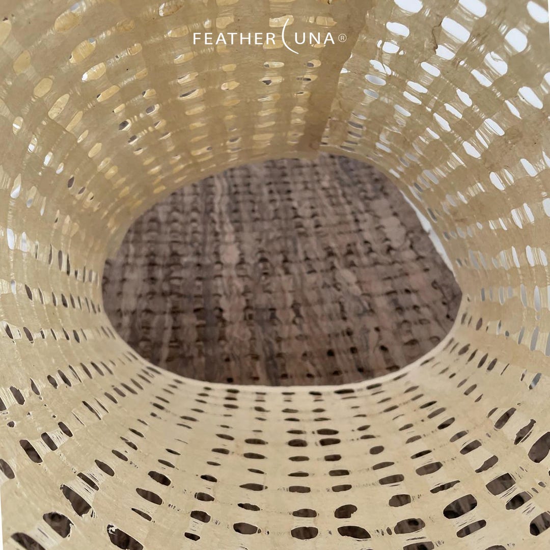 Looking down into a curved roll of Crème amate paper, with Café paper below